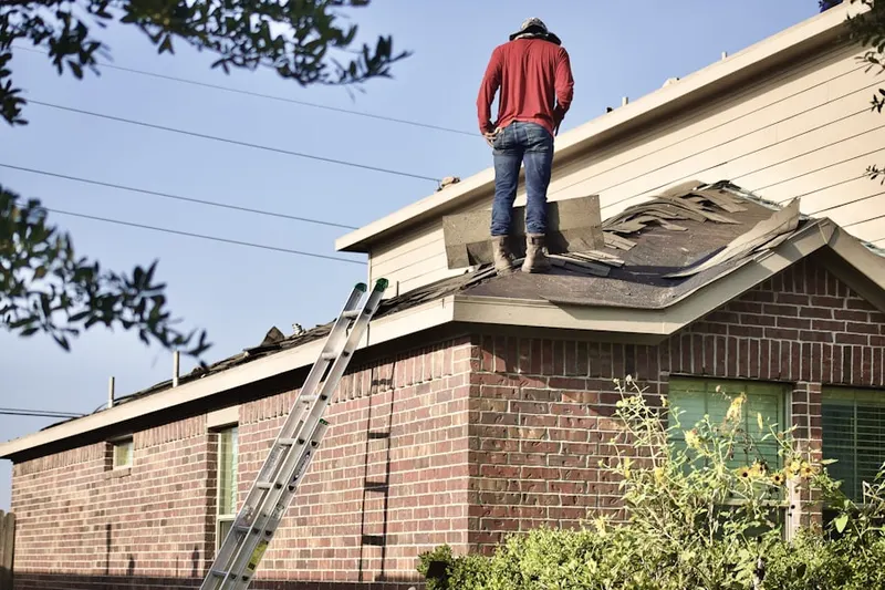 Professional roofer working on a residential roof in Girvin